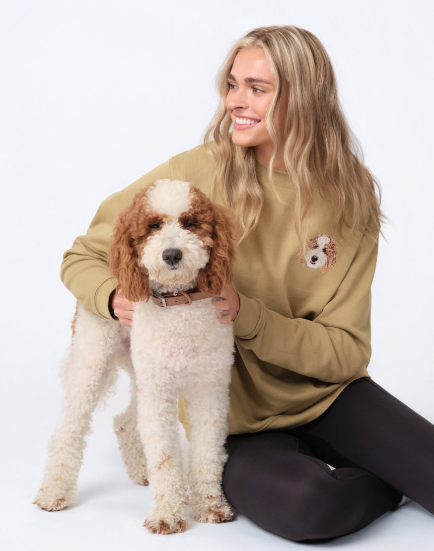 A customer in her embroidered crewneck, with her dog
